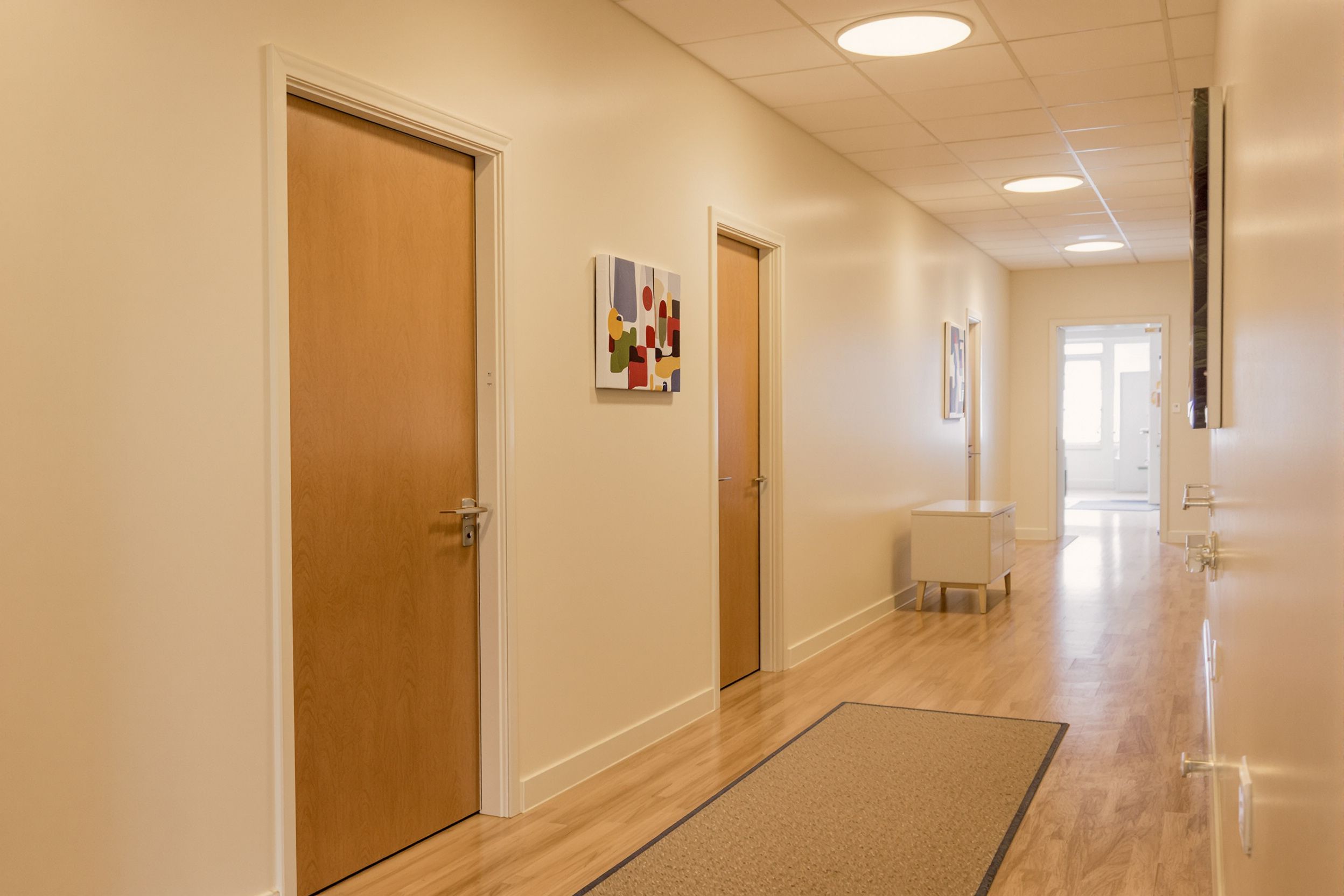 A calm clinic hallway with closed wooden doors